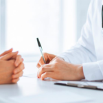 Imagem de uma mesa com médico e paciente.